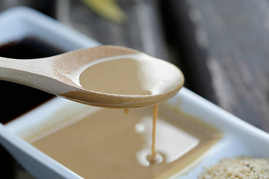 FUN Sesames Tahini Nutrition Facts |  Tahini sauce dripping from a spoon.