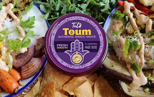 Tal’s Toum Authentic Garlic Sauce, a fresh and smooth Mediterranean garlic sauce served with roasted vegetables, rice, grilled eggplant, greens, and crispy pita chips.