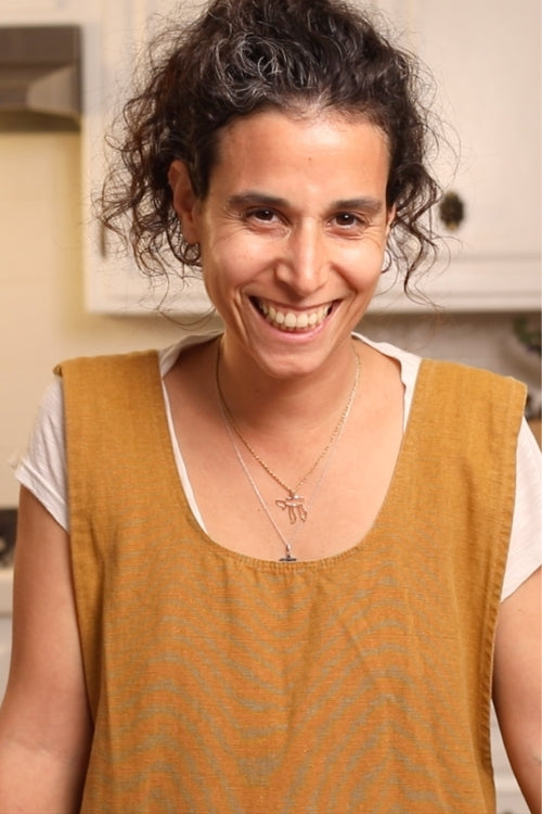 Photo of Tal Garden, founder of Tal's Mediterranean, smiling in the kitchen